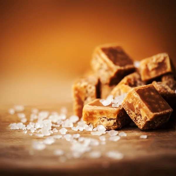 Salted caramel pieces and sea salt. — Stock Photo, Image