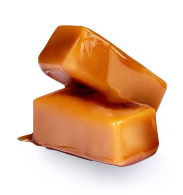 Karamel soslu tatlı karamel şekerler beyaz arka planda izole edilmiş..