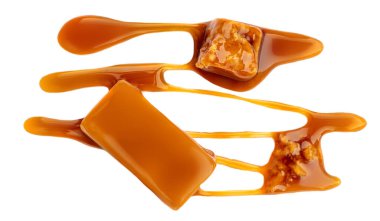 Beyaz arka planda izole edilmiş soslu akıcı karamel şekerler. Eriyen karamel makro. Üst görünüm