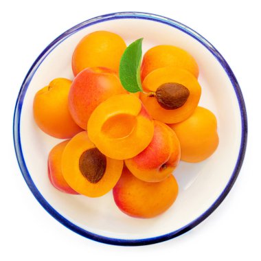 Beyaz zemin üzerinde yaprakları olan taze kayısı meyveleri. Kayısılar üst görünüm