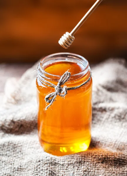 Мед в стеклянной банке с медовым соусом — стоковое фото