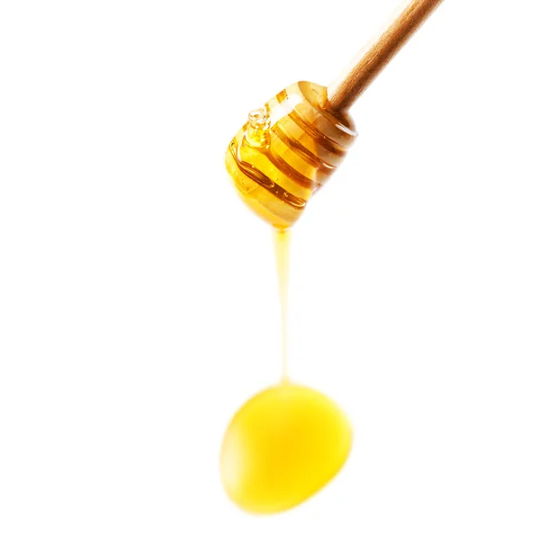 Wooden honey dipper with honey drop — Stock Photo, Image