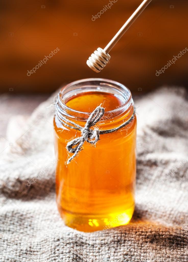 Honey in a glass jar with honey dipper