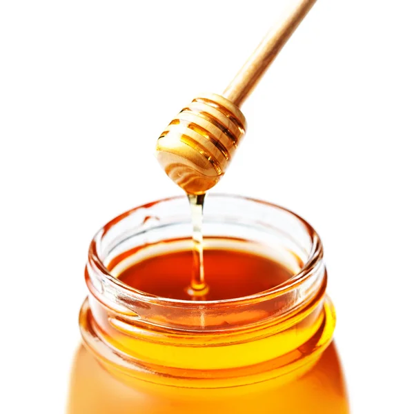 Honey in a glass jar with honey dipper — Stock Photo, Image