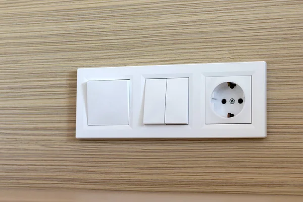 Grupo de enchufes eléctricos blancos europeos e interruptores en una pared en la habitación del hotel — Foto de Stock