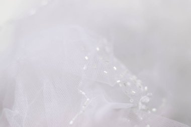 Hassas beyaz tül arka plan. Bulanık duvak ve yakın plan boncuklar. Seçici odak