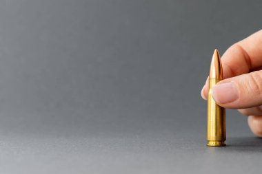 Gri arka planda bir kurşunla. Kalaşnikof taarruz tüfeği için 7.62 kalibrelik şarjör. Kopya alanı ile yakın plan.