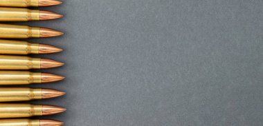 Gri kağıtlı arka plandaki kurşunlar. Kalaşnikof taarruz tüfeği için 7.62 kalibrelik fişekler.