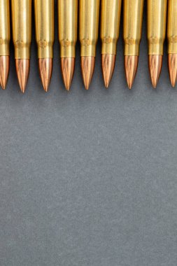 Gri kağıtlı arka plandaki kurşunlar. Kalaşnikof taarruz tüfeği için 7.62 kalibrelik fişekler, kopya alanı ile dikey pankartı kapat.