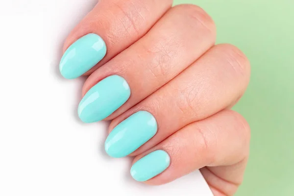 Kobieca Ręka Pięknym Manicure Miętowe Niebieskie Paznokcie Białym Smartfonem Zielonym — Zdjęcie stockowe