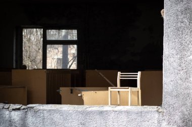 Pripyat, Çernobil Yasaklama Bölgesi, Ukrayna 'da terk edilmiş bir anaokulunun camındaki küçük tahta sandalye.