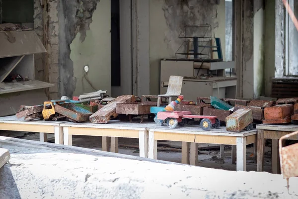 Stare Metalowe Zardzewiałe Samochodziki Drewnianych Stołach Opuszczonym Przedszkolu Mieście Widmo — Zdjęcie stockowe