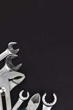 Fotokopi alanı olan koyu gri arkaplan üzerinde çalışma araçları. Üst manzara, düz yatış. Dikey fotoğraf