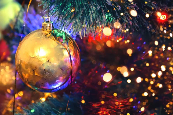 Zlatý Míč Vánočním Stromečku Barevnými Rozmazanými Světly Bokeh Selektivní Soustředění — Stock fotografie