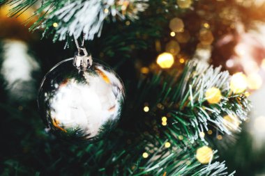 Süslü Noel ağacında gümüş top ve bulanık ışıklar bokeh. Seçici odaklanma. Yılbaşı arifesi için süslemeli tatil kartı.