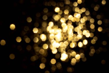 Siyah arka planda altın bulanık bokeh ışıkları. Kutlamak için ışıldayan yıldızlar