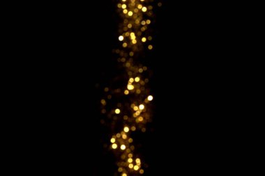 Siyah arka planda altın bulanık bokeh ışıkları. Kutlamak için ışıldayan yıldızlar