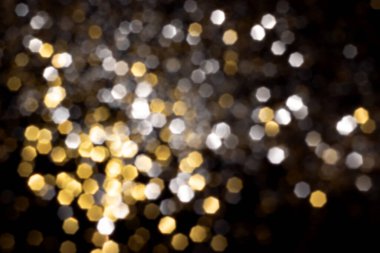 Altın ve gümüş, siyah arka planda bulanık bokeh ışıkları. Kutlamak için ışıldayan yıldızlar
