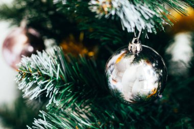 Süslü Noel ağacında gümüş top. Seçici odaklanma. Yılbaşı arifesi için süslemeli tatil kartı.