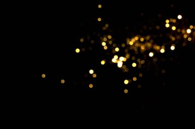 Siyah arkaplanda altın bulanık bokeh ışıkları