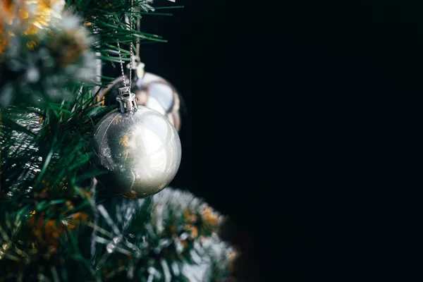 Bola de plata en el árbol de Navidad sobre fondo negro —  Fotos de Stock