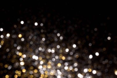 Altın ve gümüş, siyah arka planda bulanık bokeh ışıkları. Kutlamak için ışıldayan yıldızlar. Tasarımınız için üstüste