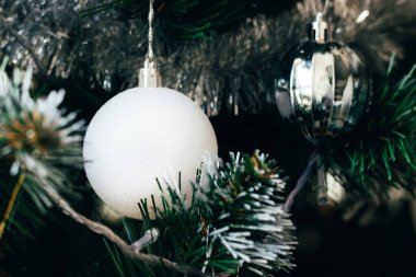 Noel ağacında beyaz balo. Seçici odaklanma. Yılbaşı arifesi için süslemeli tatil kartı.