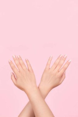 Güzel manikürlü kadın elleri pembe arka planda pembe çıplak tırnaklar. Çivi bakımı kavramı