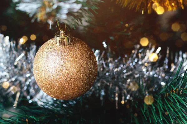 Boule dorée sur sapin de Noël avec lumières floues bokeh — Photo