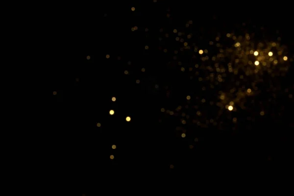 Siyah arkaplanda altın bulanık bokeh ışıkları