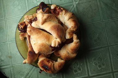 Tatlı çikolatalı kruvasanlar, eski moda geçmişlere özen gösteriyorlar. Taze ev yapımı kruvasan ve çikolata. Tabağında çikolata soslu kruvasan..