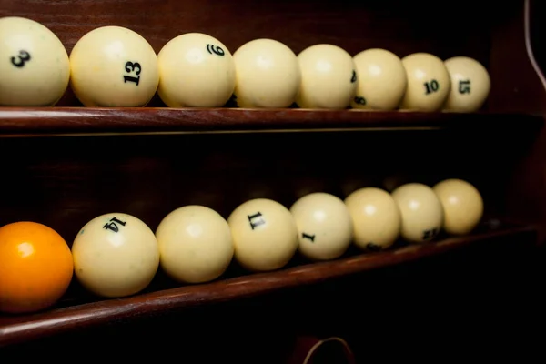 Rafta bilardo topları, Amerikan bilardosu için bilardo topları, Rus bilardosu için toplar, tahta arka planda renkli ya da beyaz toplar. Yakın plan fotoğraf. Yumuşak odak.