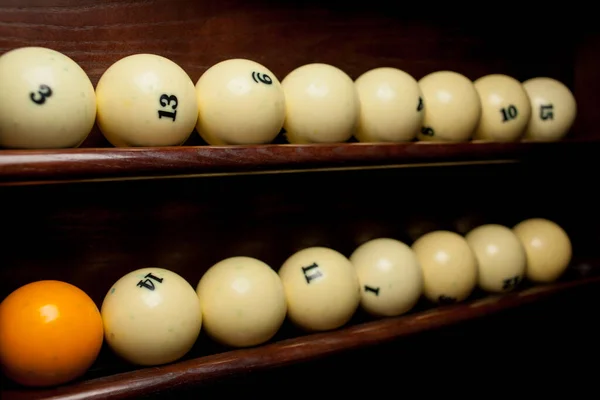Rafta bilardo topları, Amerikan bilardosu için bilardo topları, Rus bilardosu için toplar, tahta arka planda renkli ya da beyaz toplar. Yakın plan fotoğraf. Yumuşak odak.