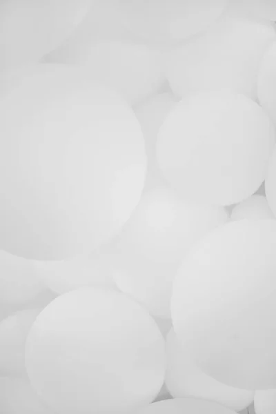 Bir sürü beyaz balon, arka plan. Bir sürü beyaz balon, şişme toplar, beyaz ve gri dairelerin arka planı. Tatil konsepti. Soyut arkaplan. Siyah beyaz fotoğraf.