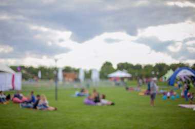 Millet, aile eğlence parkında. Halk parkında aile veya arkadaşlarla piknik yapan soyut bulanık insanlar, şehir eğlence yaşam tarzı. Odaklanmamış arka plan. Rahatlama ve dinlenme konsepti.