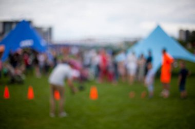 Millet, aile eğlence parkında. Halk parkında aile veya arkadaşlarla piknik yapan soyut bulanık insanlar, şehir eğlence yaşam tarzı. Odaklanmamış arka plan. Rahatlama ve dinlenme konsepti.