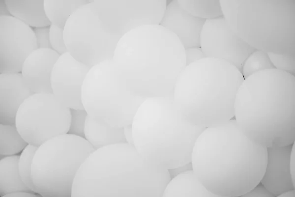 Bir sürü beyaz balon, arka plan. Bir sürü beyaz balon, şişme toplar, beyaz ve gri dairelerin arka planı. Tatil konsepti. Soyut arkaplan. Siyah beyaz fotoğraf.