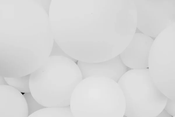 Bir sürü beyaz balon, arka plan. Bir sürü beyaz balon, şişme toplar, beyaz ve gri dairelerin arka planı. Tatil konsepti. Soyut arkaplan. Siyah beyaz fotoğraf.