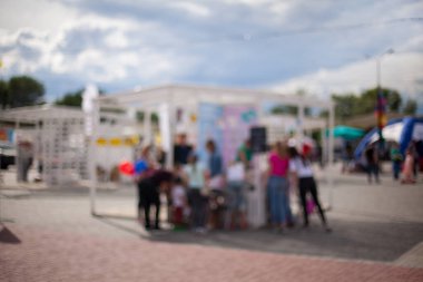 Millet, aile eğlence parkında. Halk parkında aile veya arkadaşlarla piknik yapan soyut bulanık insanlar, şehir eğlence yaşam tarzı. Odaklanmamış arka plan. Rahatlama ve dinlenme konsepti.