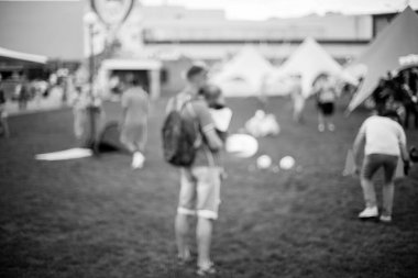 Millet, aile eğlence parkında. Halk parkında aile veya arkadaşlarla piknik yapan soyut bulanık insanlar, şehir eğlence yaşam tarzı. Odaklanmamış arka plan. Siyah ve beyaz işleme