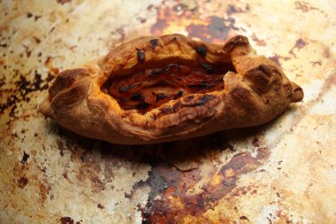 Masada lahana ile doldurulmuş bükülmüş hamur işi. Rus açık pirozhki, lahana ile doldurulmuş fırında köfteler. Evde kızarmış lahana ve lahana. Geleneksel sıcak Rus köfteleri fırından yeni çıktı..