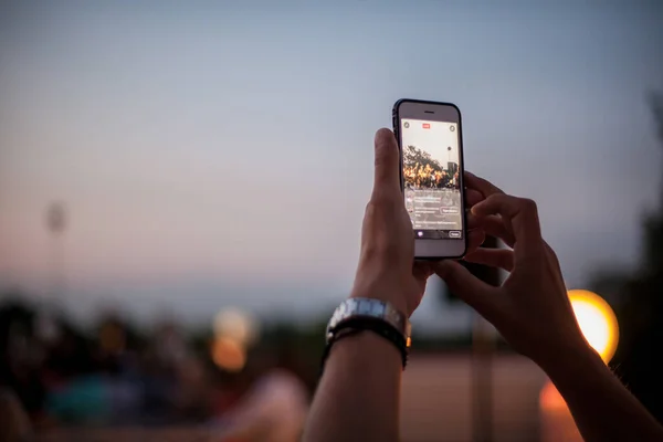 Telefonda fotoğraf çeken insanların siluetleri. Adam cep telefonuyla günbatımının fotoğraflarını çekiyor. Fotoğraf çeken insanların silueti. Köprüde fotoğraf çeken biri.