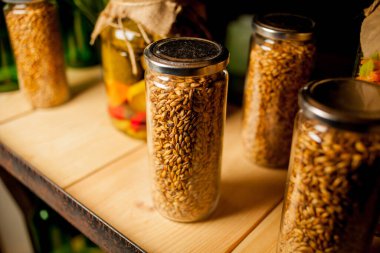 Kırsal ahşap rafta yulaf ezmeli cam kavanoz, mutfakta kopyalama alanı. Sağlıklı beslenme, detoks ya da diyet konsepti. Rafta tahıllı cam kavanozlar..