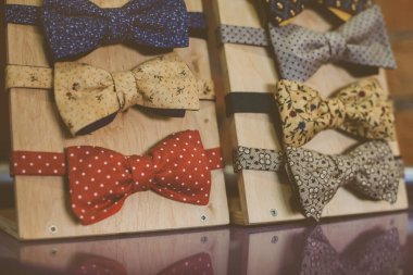 Çok renkli erkek papyonları. Burun bağı. Ahşap bir stantta çok renkli erkek papyonları. Burun bağları ahşap bir stantta. Berber dükkânı gösterisi. Fotoğraf stili vintage biçimi