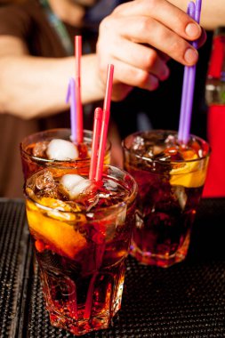 Bar arka planında bir bardak buzlu kokteyl. Siyah arka planda Bokeh ışığı olan camlı bir Wiskey. Bir bardak viski. Barın arka planında bir bardak viski ve buz..