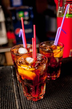 Bar arka planında bir bardak buzlu kokteyl. Siyah arka planda Bokeh ışığı olan camlı bir Wiskey. Bir bardak viski. Barın arka planında bir bardak viski ve buz..