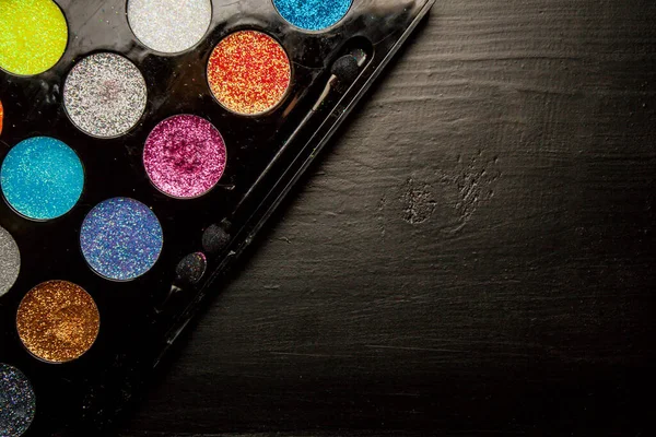 Colorful makeup palette on black background. Palette of colorful eye shadows, close-up.