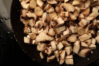 Bir tavada mantar parçaları. Tavada çiğ mantar parçaları. çiğ mantar pişirmek
