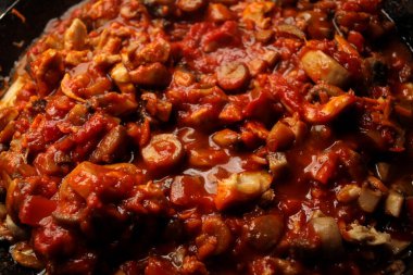 Vejetaryen mantarları, nohut güveci, siyah arka planda demir bir tavada, üst manzara. Sağlıklı vejetaryen gıda konsepti. Vejetaryen biberi. 