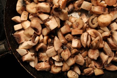 Bir tavada mantar parçaları. Tavada çiğ mantar parçaları. çiğ mantar pişirmek